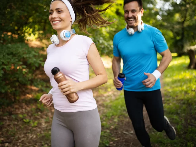 Two adults running outside in Louisiana heat while learning hydration and heat safety tips from MOPE Clinic in Metairie